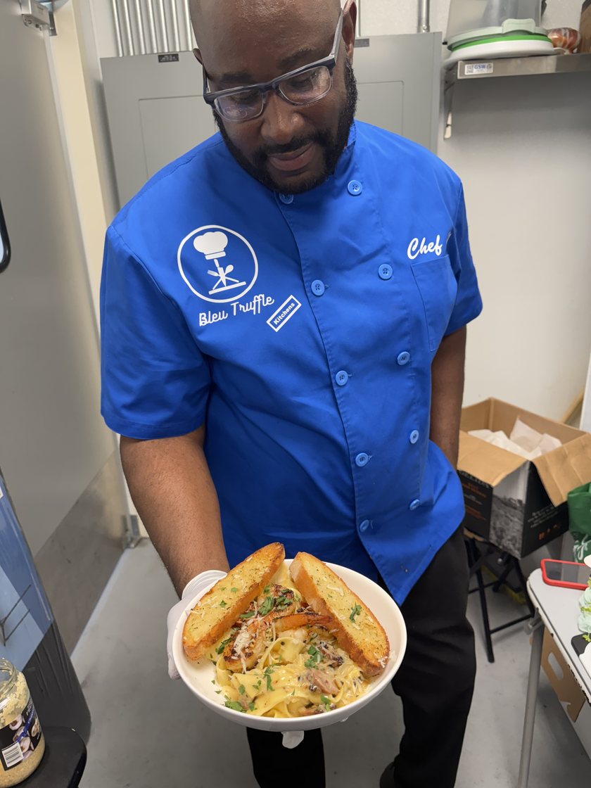 Chef Al carrying a finished plate out of the kitchen.