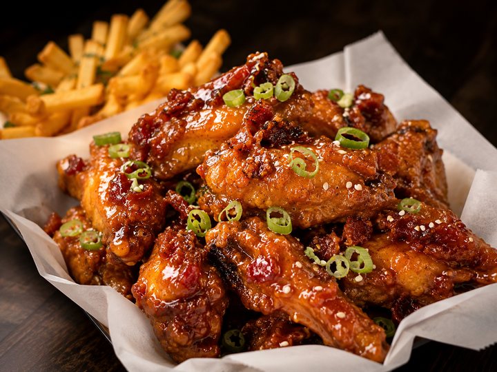 Maple Bacon Bourbon Wings glazed and scattered with bacon and green onion, served with fries.